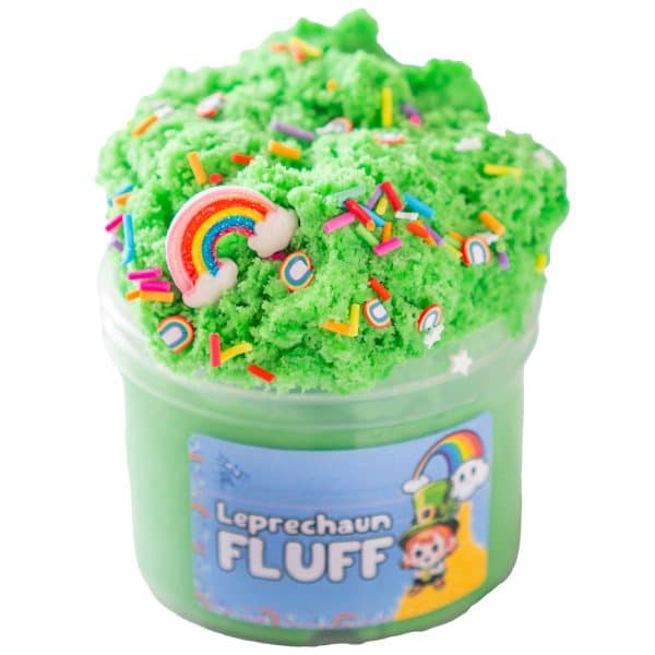 A translucent jar is over filled and piled high with a bright green fluffy cloud slime topped with a rainbow charm and rainbow sprinkles. A blue label on the jar has an image of a leprechaun and a rainbow and reads, Leprechaun Fluff Slime.
