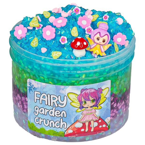 A translucent jar is filled layers of bingsu bead slime in light pink, lilac, deep purple, green, and turquoise. The rounded top is dotted with flower and leaf sprinkle, a red and white mushroom charm, and a fairy charm. The label reads Fairy Slime.